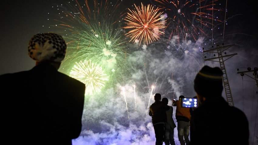 People watch fireworks as part of the New Year celebrations on January 1, 2020. (Photo by FAROOQ NAEEM/AFP via Getty Images)