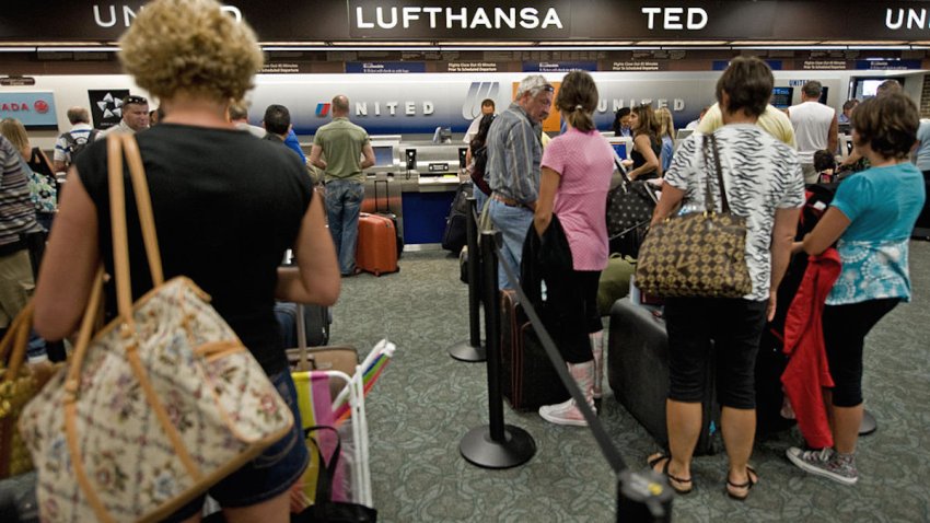 Airline travelers line up for check-in at Tampa International Airport May 24, 2008.   AFP Photo/Paul J. Richards (Photo credit should read PAUL J. RICHARDS/AFP via Getty Images)