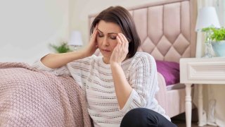 Foto ilustrativa de una mujer madura, cansada, que sufre de dolor de cabeza.