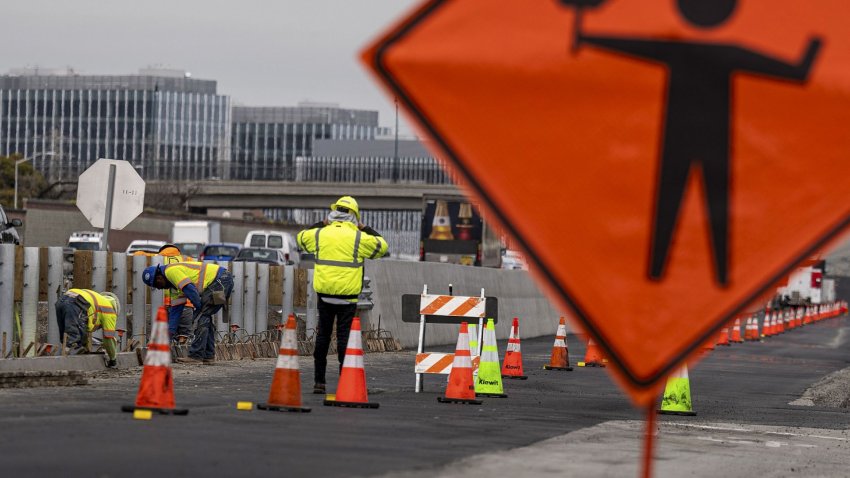 Contractors work on a road under repair along Highway 101 in San Mateo, California, U.S., on Wednesday, March 17, 2021.