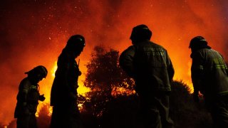 Foto de un grupo de bomberos chilenos frente a un incendio.