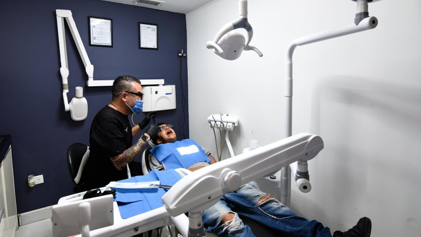 El cirujano maxilofacial de origen venezolano, Oswaldo Hernández Tabata, atiende  a un paciente en su consultorio dental el 16 de julio de 2023 en la fronteriza Ciudad Juárez, Chihuahua (México). EFE/Luis Torres