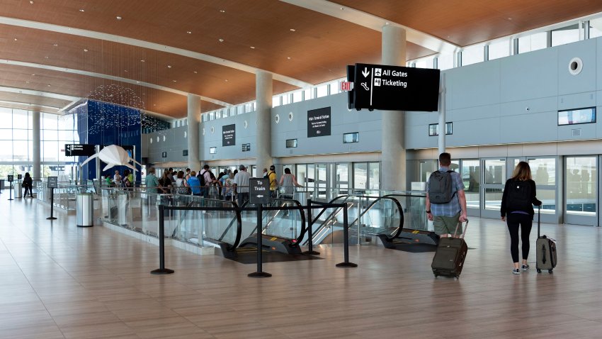 Aeropuerto Internacional de Tampa, Florida. Pasajeros esperan en la estación de la terminal principal el tren que les llevará al aparcamiento Economy y al centro de alquiler de coches.