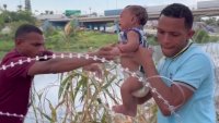 En video: familia cruza con un bebé la malla de alambre de púas en la frontera