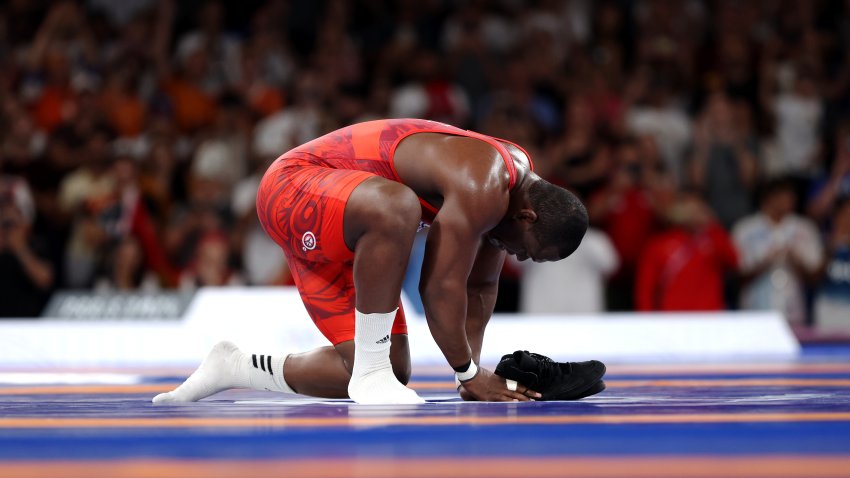 PARIS, FRANCE – AUGUST 06: Mijain Lopez Nunez of Team Cuba removes his shoes to signify his retirement following his victory and earning of fifth Olympic Gold during the Wrestling Men’s Greco-roman 130kg Gold Medal match against Yasmani Acosta Fernandez of Team Chile (not pictured) on day eleven of the Olympic Games Paris 2024 at Champs-de-Mars Arena on August 06, 2024 in Paris, France. (Photo by Sarah Stier/Getty Images)