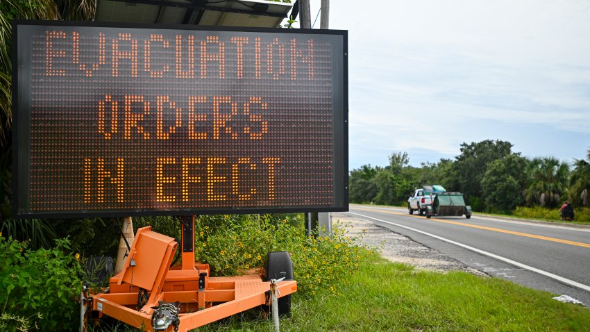 A sign displays evacuation orders as preparations are made for the arrival of Hurricane Helene, in Cedar Key, Florida on September 25, 2024. Thousands of residents on Wednesday began evacuating parts of coastal Florida as the US state braces for Hurricane Helene, forecast to barrel ashore as a powerful, potentially deadly storm. Helene strengthened into a hurricane mid-morning in the Gulf of Mexico and is “expected to bring life-threatening storm surge, damaging winds, and flooding rains to a large portion of Florida and the Southeastern United States,” the National Hurricane Center in Miami said in its latest bulletin. (Photo by Miguel J. Rodriguez Carrillo / AFP) (Photo by MIGUEL J. RODRIGUEZ CARRILLO/AFP via Getty Images)