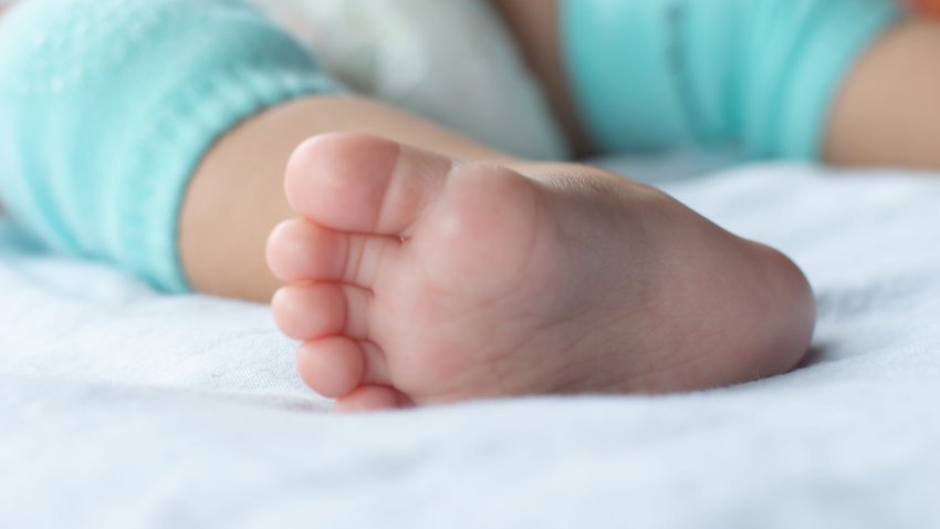 Close-up of the baby’s soft feet on the mattress
