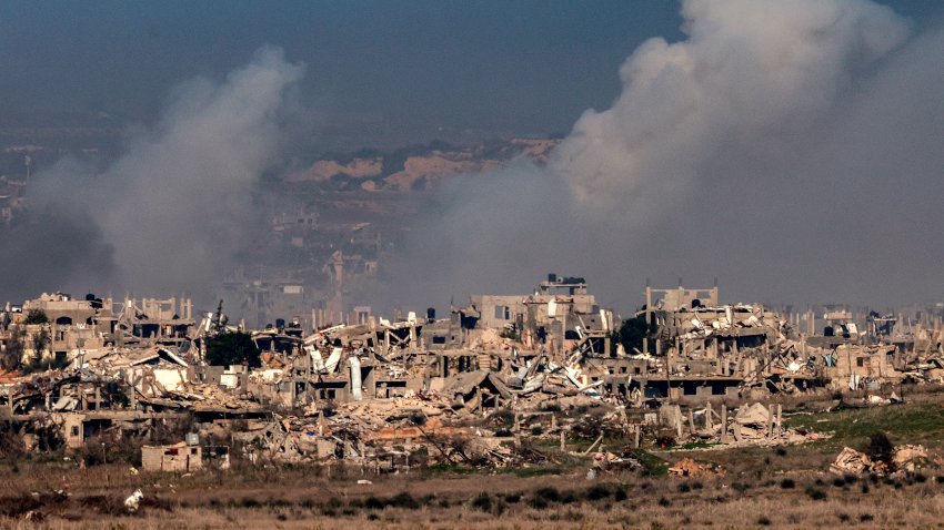 Esta imagen tomada desde el lado israelí de la frontera con la Franja de Gaza muestra columnas de humo detrás de edificios destruidos en el norte de la Franja de Gaza el 13 de enero de 2025, en medio de la guerra en curso entre Israel y Hamás.