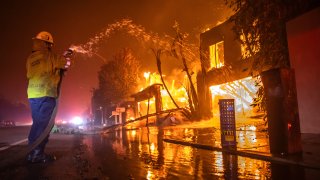 Un bombero lucha el viernes contra las llamas en el incendio en Palisades.