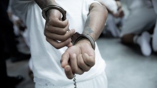 En esta foto proporcionada por el gobierno salvadoreño, se aprecian de cerca las esposas colocadas en las manos de un recluso recién ingresado, presuntamente vinculado a organizaciones criminales, en el CECOT el 16 de marzo de 2025 en Tecoluca, El Salvador.