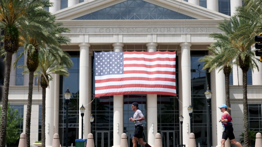JACKSONVILLE, FLORIDA – MAY 16: Competitors pass Duval County Clerk of Courts during the run portion of IRONMAN Jacksonville on May 16, 2026 in Jacksonville, Florida.  (Photo by Steph Chambers/Getty Images for IRONMAN)